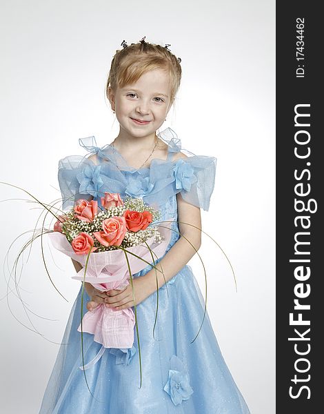 The girl holds a bunch of flowers, looks in a shot and smiles. The girl holds a bunch of flowers, looks in a shot and smiles