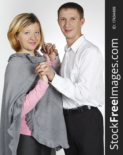 The man embraces the woman, the woman holds a bouquet