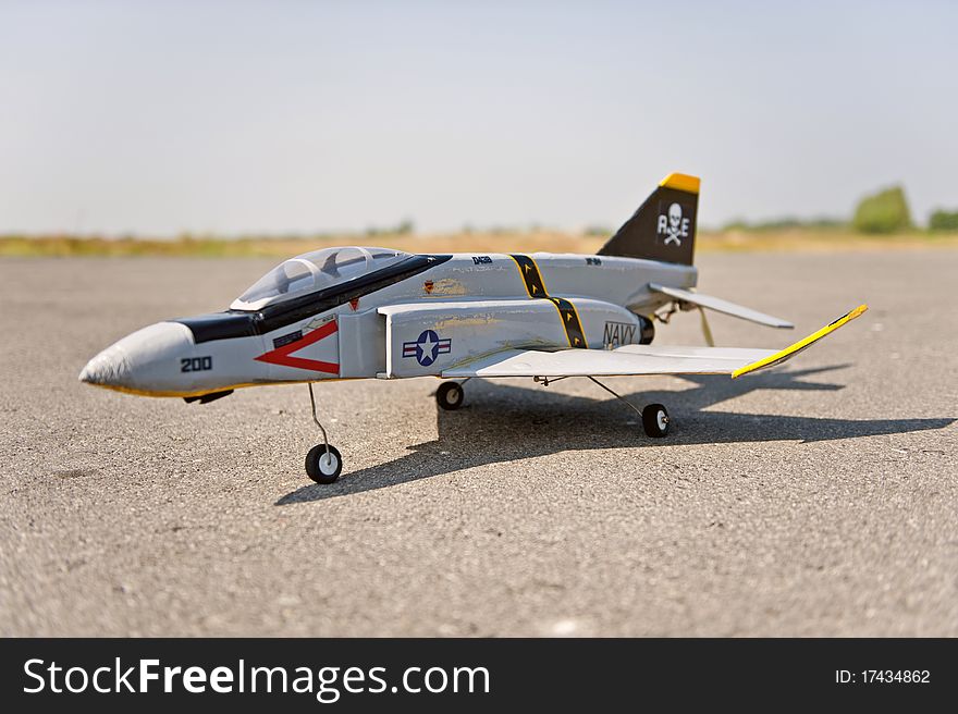 Homemade radio control toy aircraft with electric motor on runway.