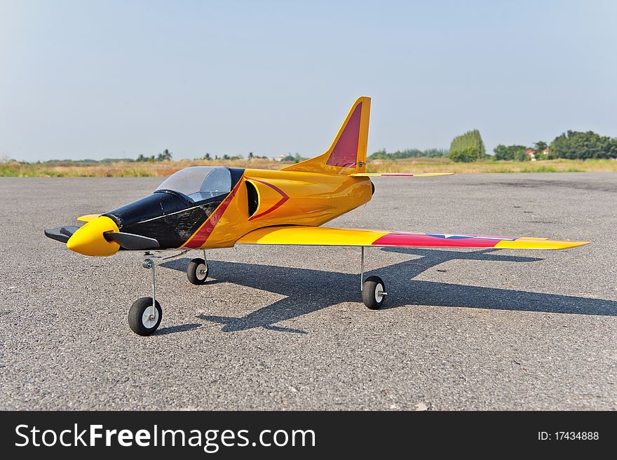 Homemade radio control toy aircraft with electric motor on runway.