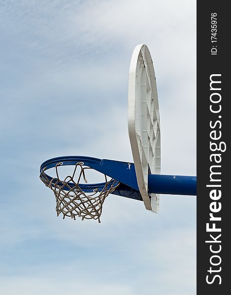 A basketball hoop and backboard in an outdoor playground. A basketball hoop and backboard in an outdoor playground.