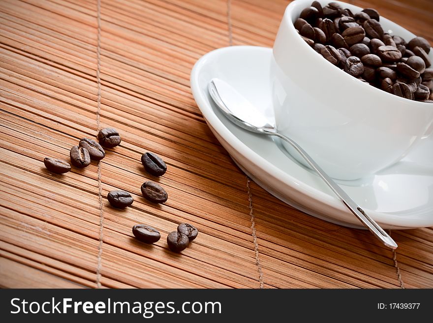 Cup with coffee beans on a grunge wooden background