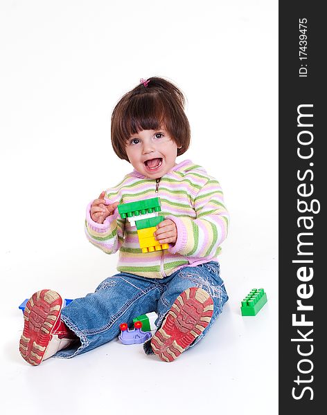 Cute little girl is constructing using building blocks