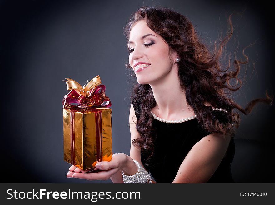 Beautiful young brunette woman with a present