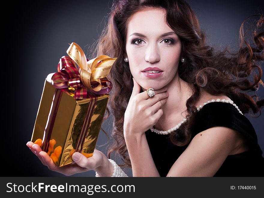 Beautiful young brunette woman with a present