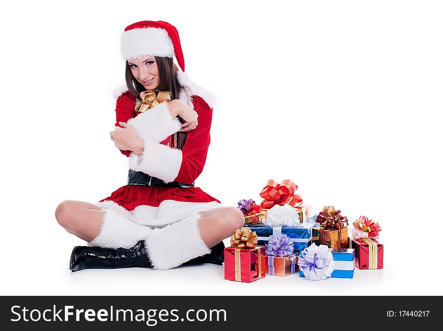 Beautiful girl dressed as Santa Claus sitting with a bunch of gifts isolated with white background