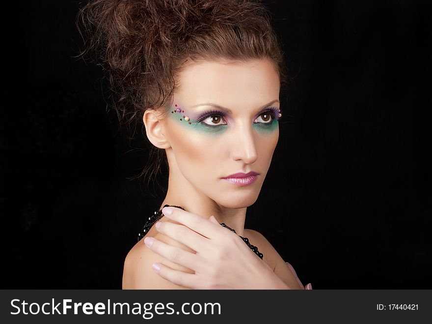 Portrait of young woman with creative make-up on black