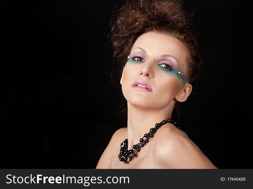 Portrait of young woman with creative make-up on black