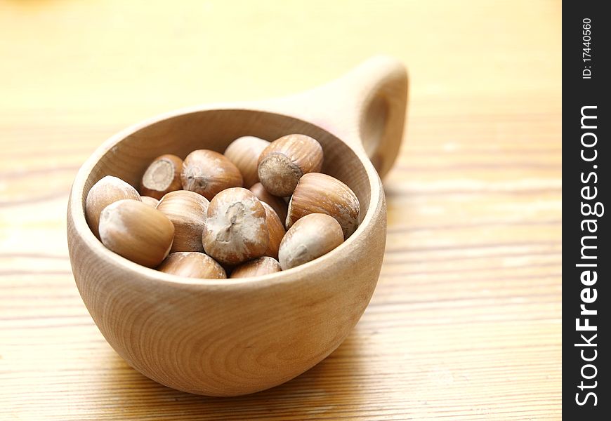 Hazelnuts in a wooden cup on a table