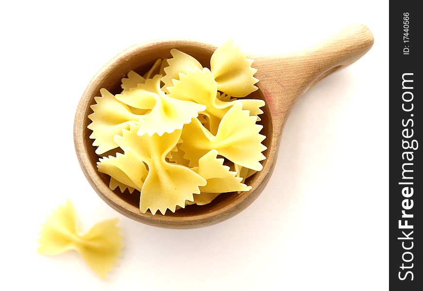 Farfalle pasta in a wooden cup on white background