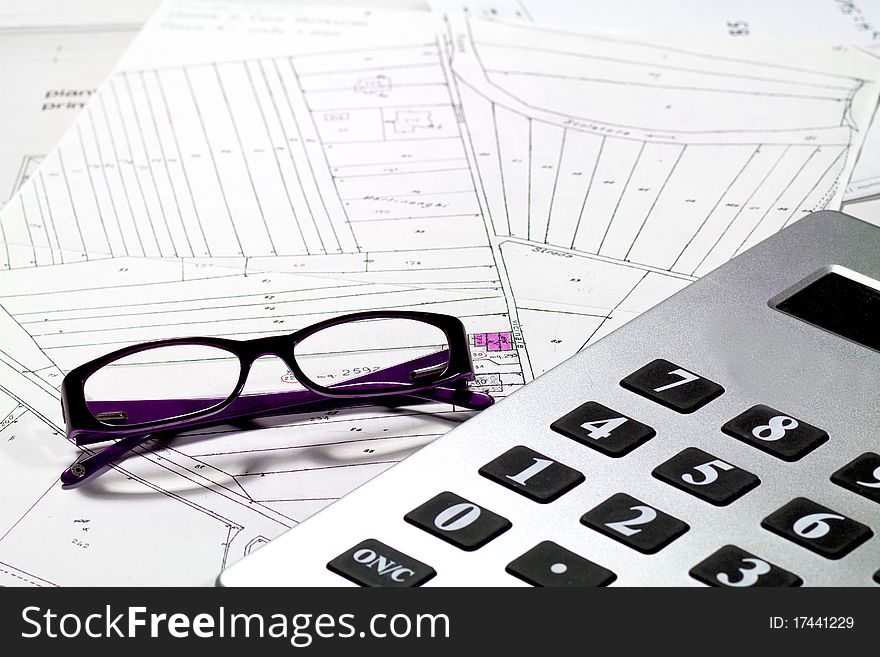 Calculator and eyeglasses with technical drawings. Calculator and eyeglasses with technical drawings