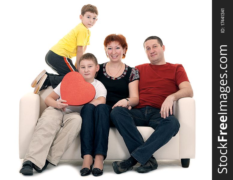 Family silit on the couch in the hands of a red decorative heart