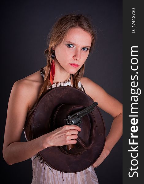 The American Indian girl with a cowboy's hat holds a pistol