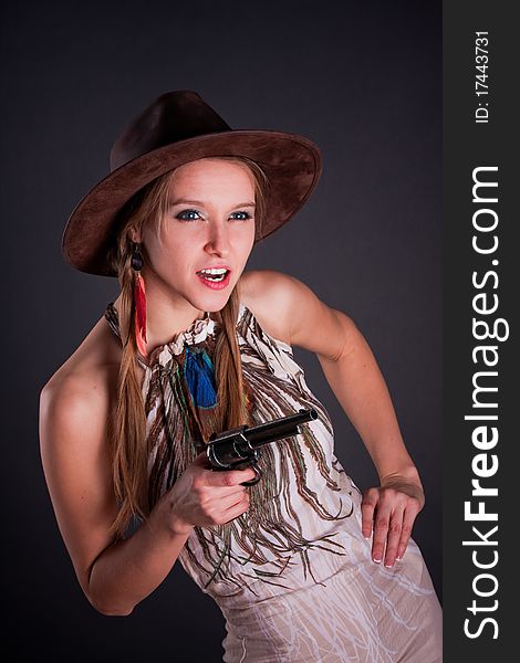 The American Indian girl in a cowboy's hat holds a pistol