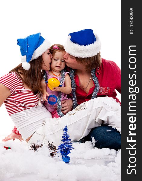 Parents in Santa's hat kissing their child in artificial snow isolated on white