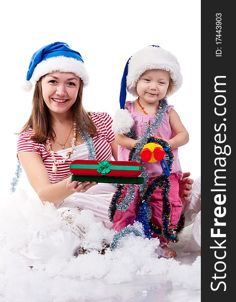 Mother and daughter in Santa's hat sitting in artificial snow isolated on white