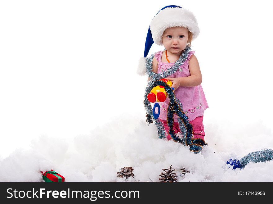 Baby in Santa's hat in tinsel and artificial snow isolated on white