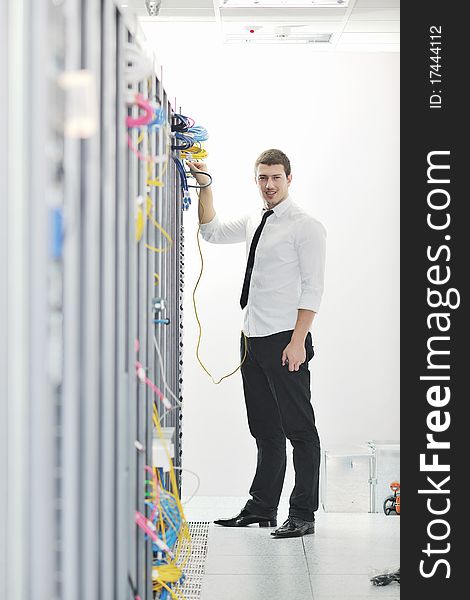 Young handsome business man  engeneer in datacenter server room. Young handsome business man  engeneer in datacenter server room