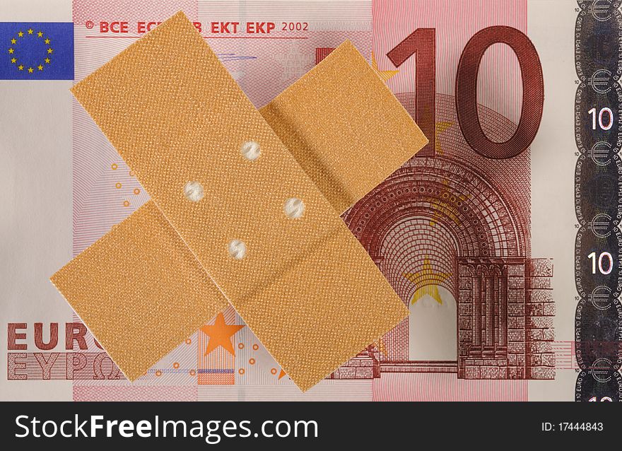 Euro banknote and medical wound bandage as symbol for costs at health care. Euro banknote and medical wound bandage as symbol for costs at health care