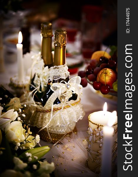 Bottle of champagne and candles on wedding table