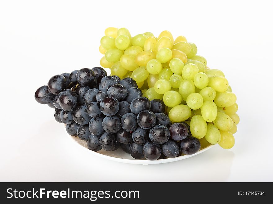 A plate with black and green grapes. A plate with black and green grapes