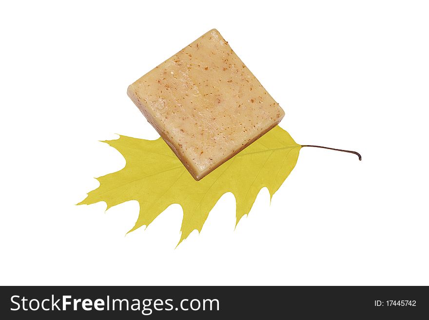 Spa towel and soap with yellow leaves on a white