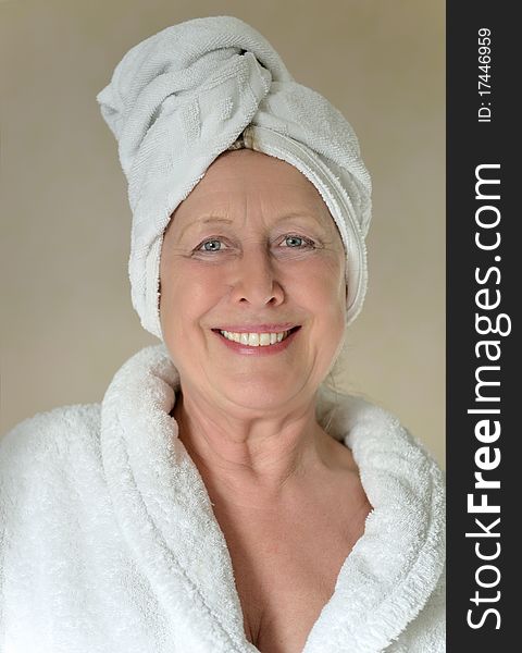 Color portrait photo of a Happy woman with towel wrapped around her head.