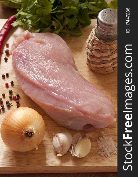 Raw Meat, Onion, Garlic And Spices On Wooden Board