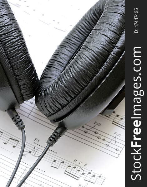 Black earphones with notes in background