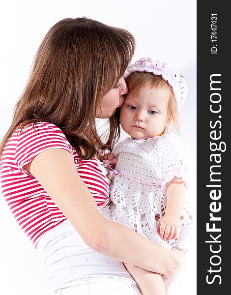 Mother kissing her daughter isolated on white