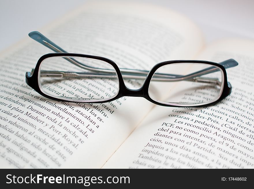 Glasses over a book, symbolizing education, reading.