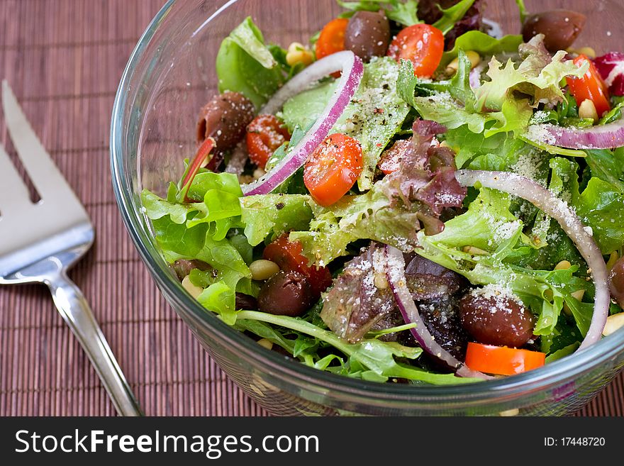 A big bowl of salad with a serving fork.