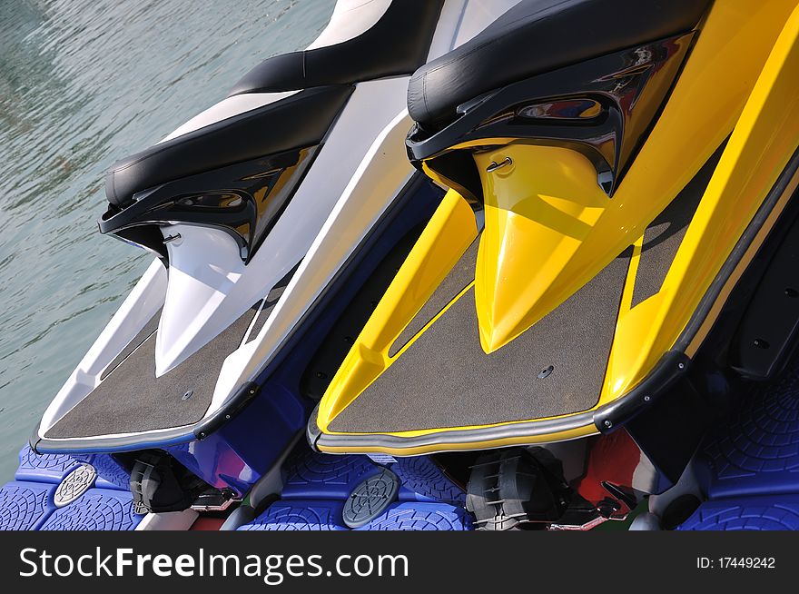 Part of two motor boat body in yellow and white color, beside water, shown as water sport or holiday and entertainment. Part of two motor boat body in yellow and white color, beside water, shown as water sport or holiday and entertainment.