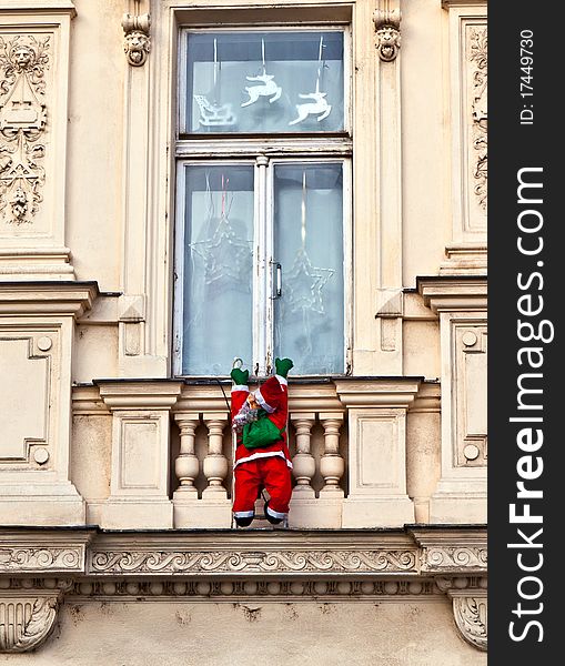 Santa claus is climbing up a facade
