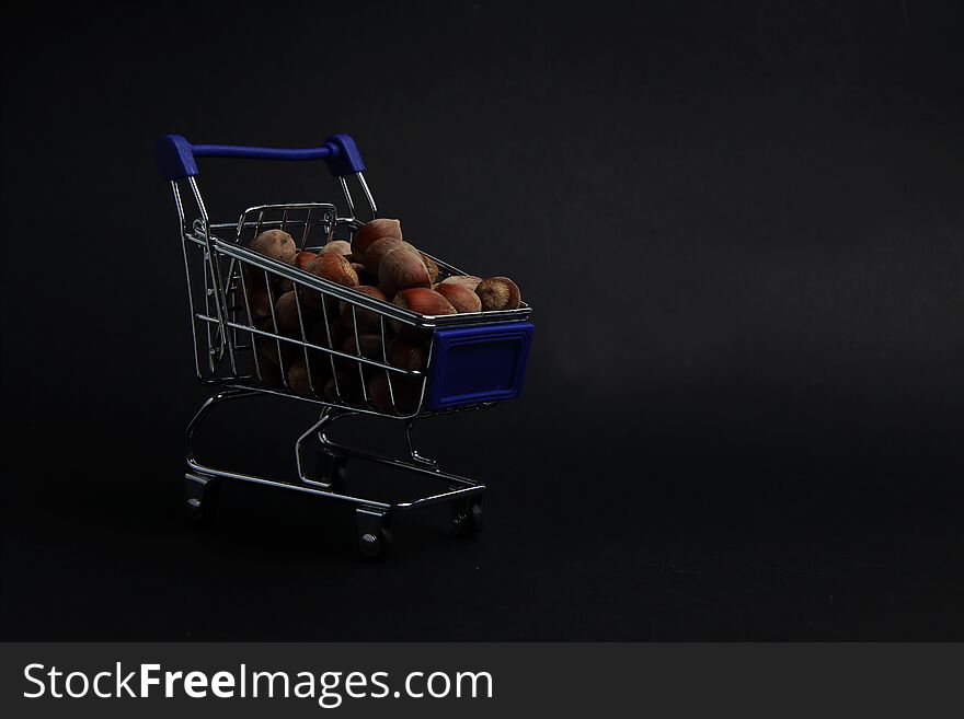 A shopping cart of filbert isolated on black background close up. Image contains copy space