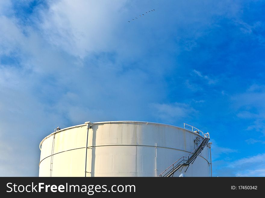 White tanks in tank farm with iron staircase in snow. White tanks in tank farm with iron staircase in snow