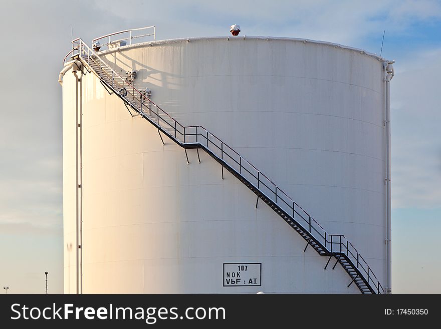 White tanks in tank farm with iron staircase in snow. White tanks in tank farm with iron staircase in snow