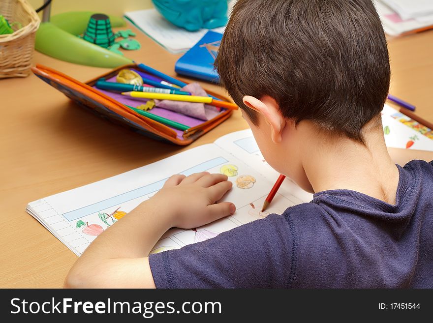 Boy doing homework with color pencil, painting fruits. Boy doing homework with color pencil, painting fruits