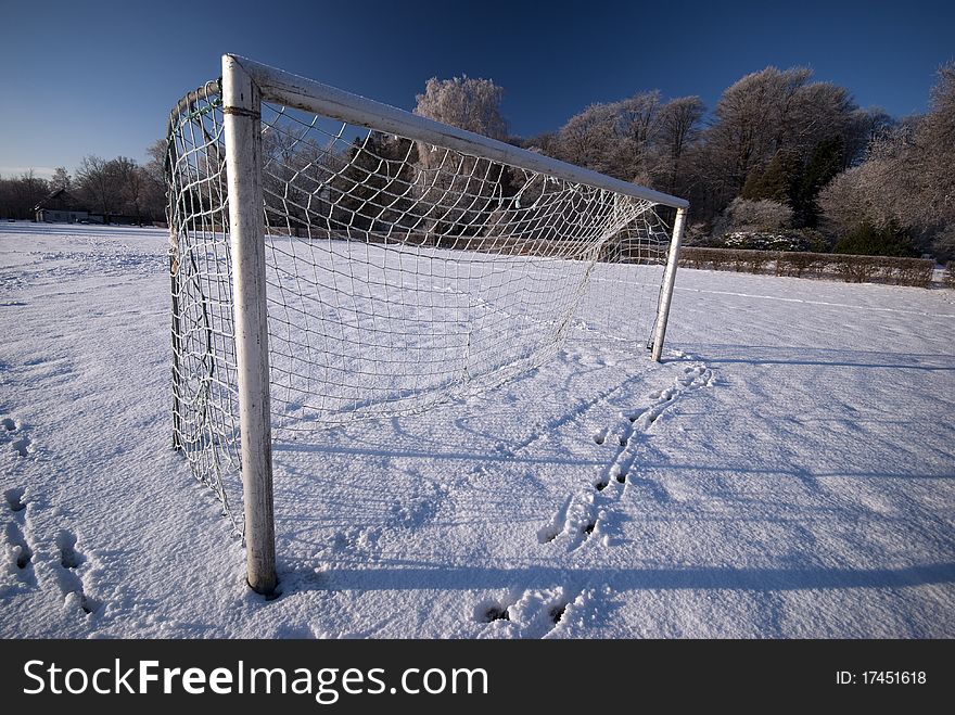Soccer goal and field in winter snow. No green grass.
