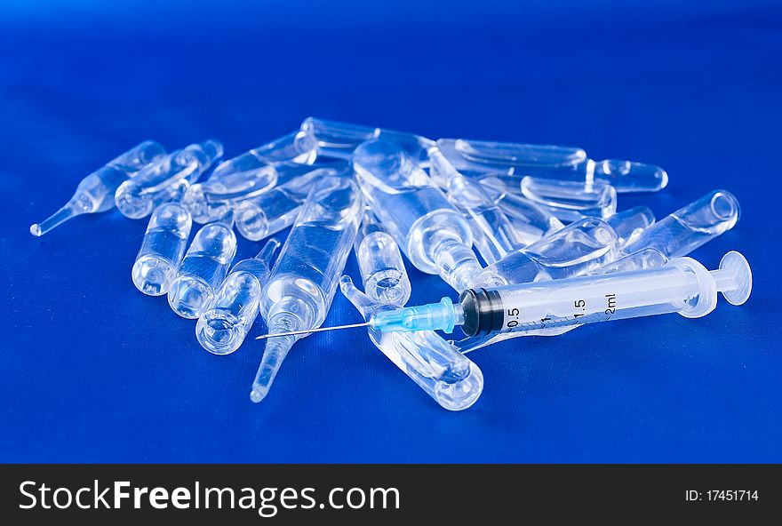 Vials and a syringe on a blue background