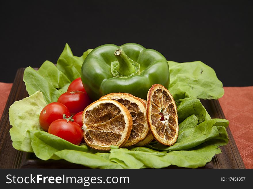 Paprika and cocktail tomatoes with lemon onto lettuce leaves