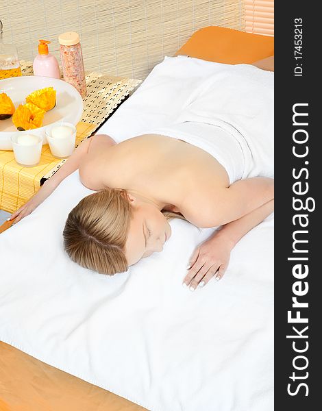 Woman in spa on white towel with blond hair