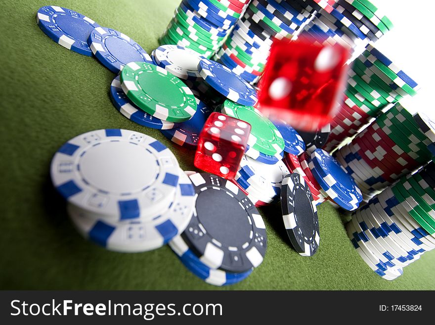 Red casino dice falling on a pile of poker chips