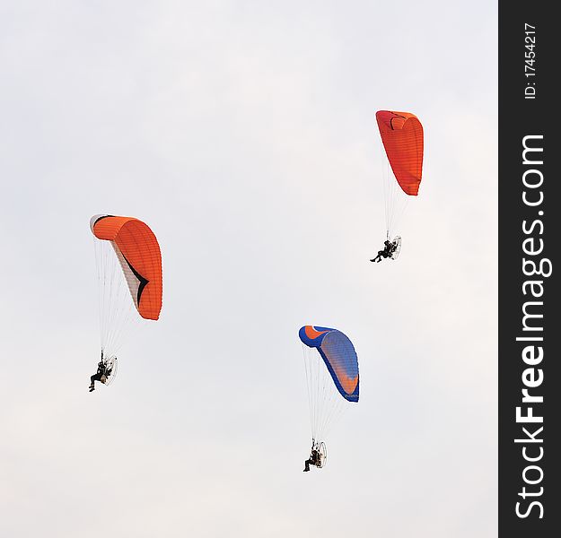 Two Paramotors flying against blue sky