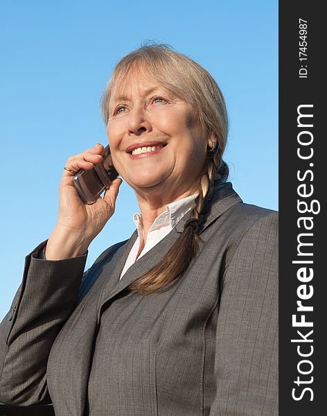 Color portrait photo of a Happy mature businesswoman using cellphone.