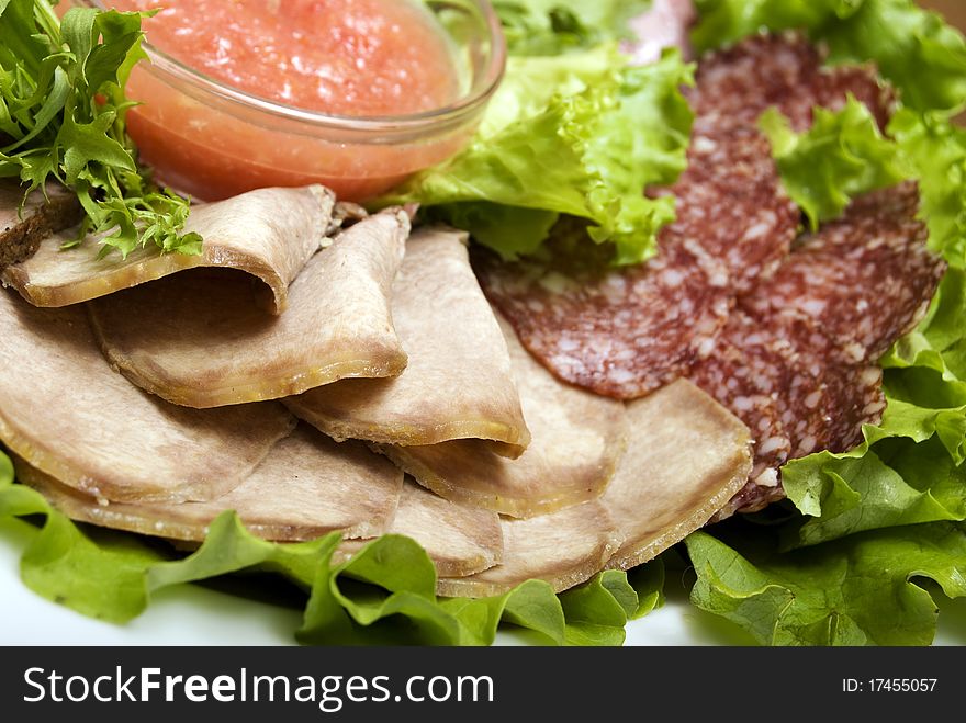 Appetizer made of meat delicacies and salad. Appetizer made of meat delicacies and salad