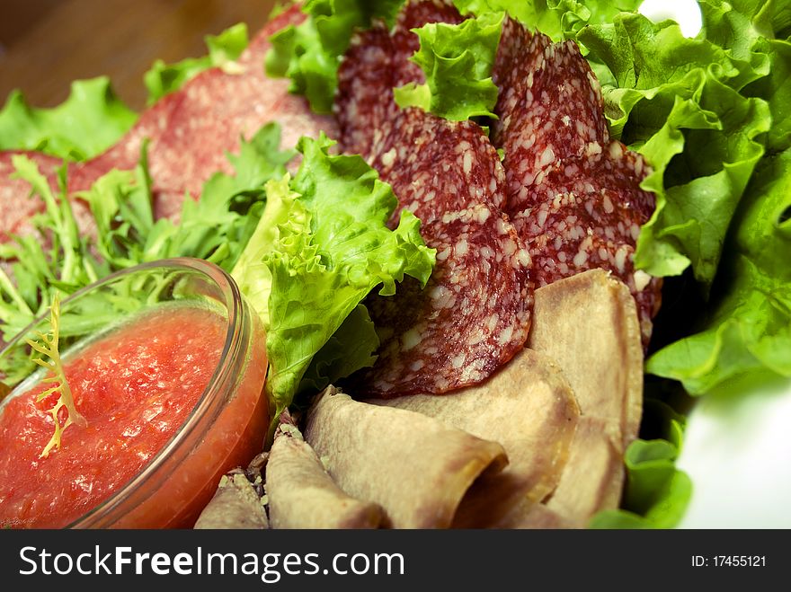 Appetizer made of meat delicacies and salad. Appetizer made of meat delicacies and salad
