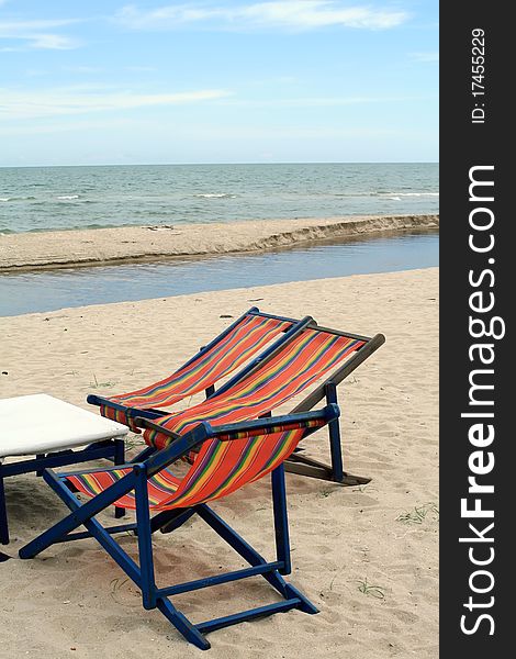 Sun beach chairs on shore near sea