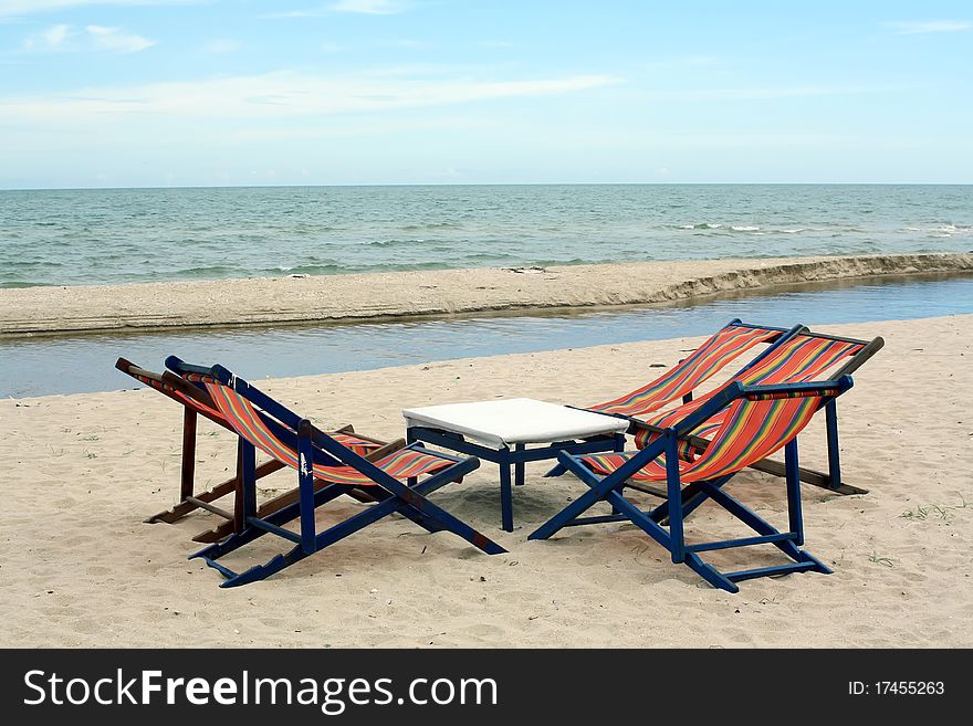 Sun beach chairs on shore near sea