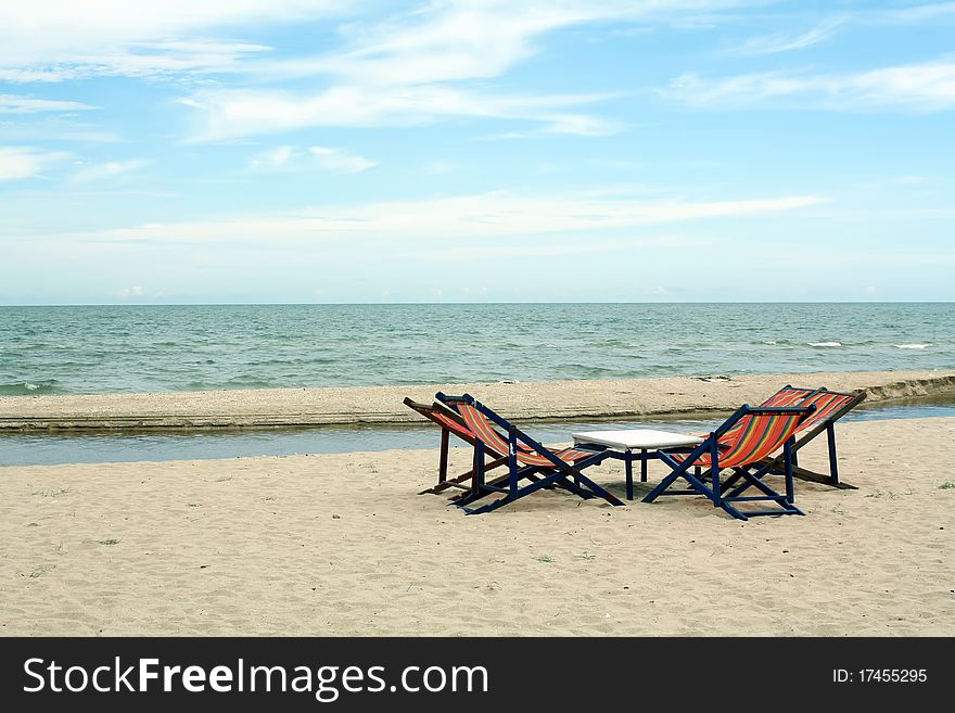 Sun beach chairs on shore near sea